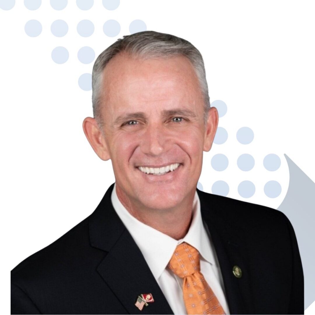 <b>Rowdy Oxford</b> Smiling man in suit with orange tie